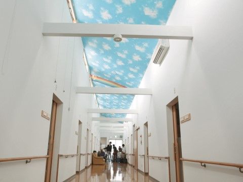 天井に青空が描かれた通路は、吹き抜けになっておりとても開放的である。手すりが設置され、安全に歩行することができる。