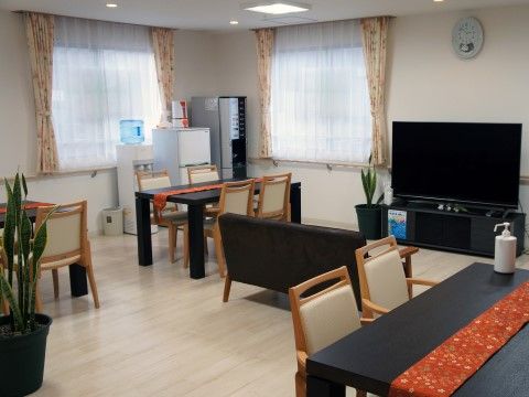食堂のテーブルは黒く、赤い布で装飾されている。室内は華やかな様子で、入居者様の心の癒しとなる空間である。