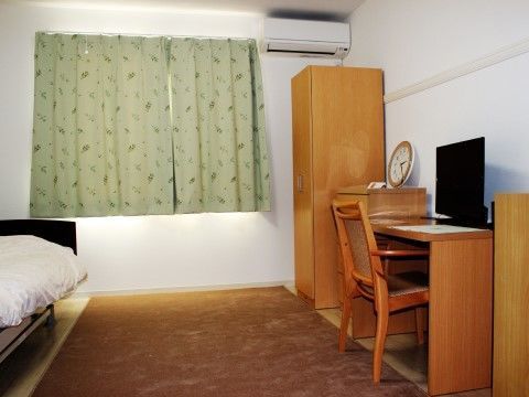クローゼットやキャビネット、テレビを置いたテーブルが揃っている居室