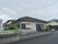 施設は1階建ての建物である。グレー系の壁に黒いフレームの窓が並んでいる。窓には日よけ用のシートが掛けられている。