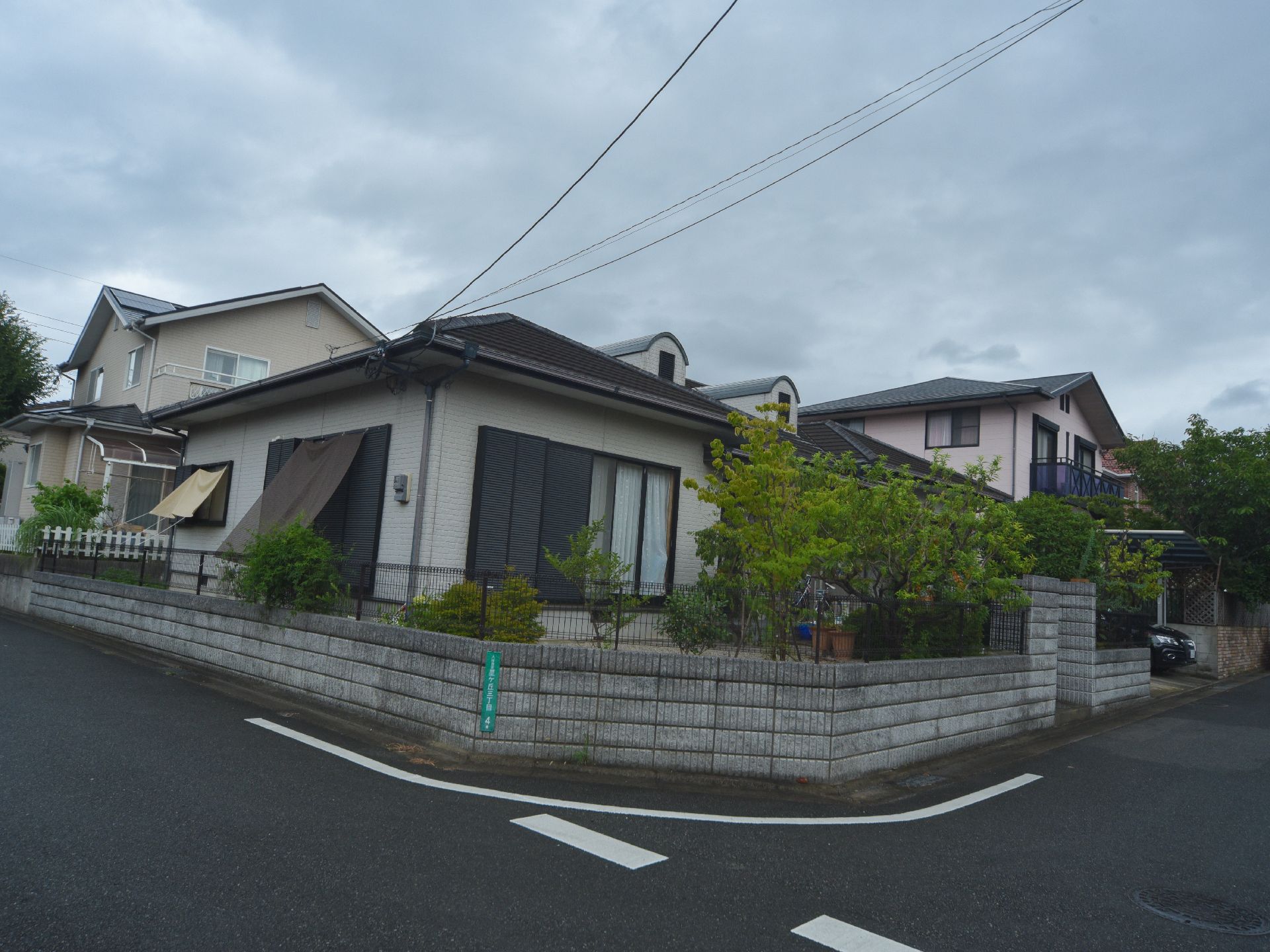 施設は道路の曲がり角部分に建っている。外周には低いブロック塀があり、上部にワイヤーの黒いフェンスが付いている。