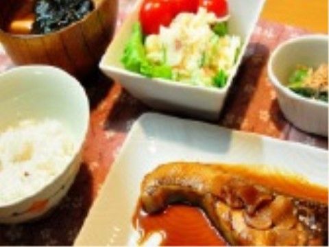 魚の煮付けとポテトサラダ、味噌汁と小鉢が配膳された食事