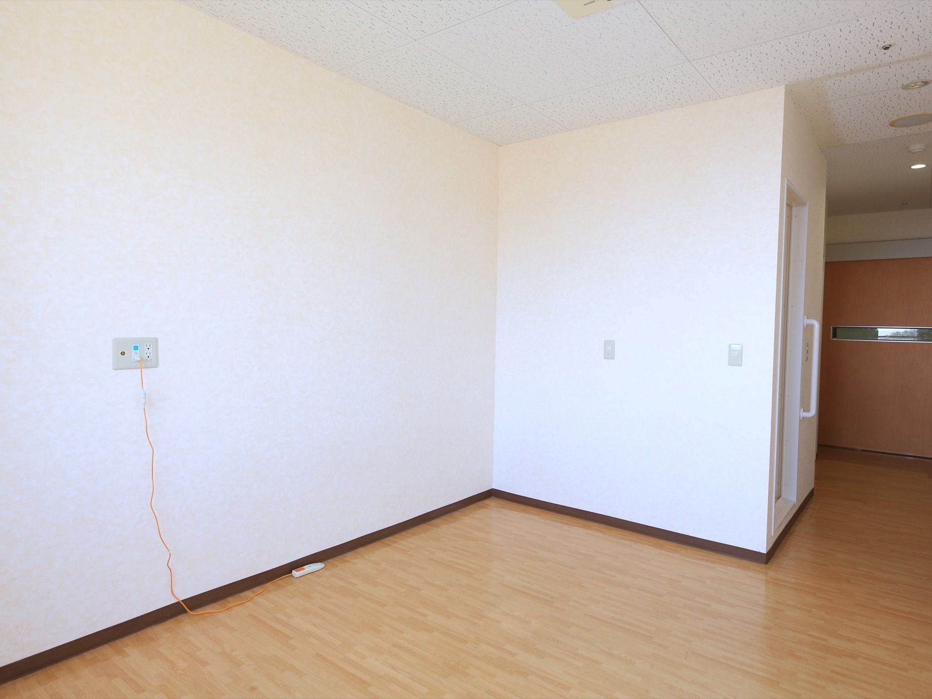 フローリング床の広い部屋である。天井と壁は白で統一されている。壁に緊急通報用のナースコール取りつけてある。