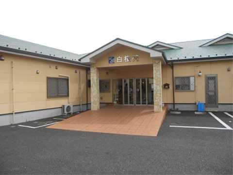 ブラウンのタイルの幅が広いスロープを設けた施設の玄関