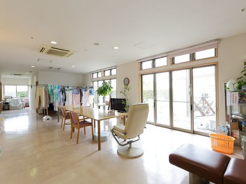 大きな窓から室内に日光が入り込んでいる。多人数がけのテーブルと椅子やテレビがゆったりと用意してある。