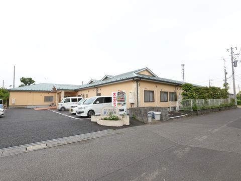 施設外観と、自動販売機が設置してある施設専用駐車場