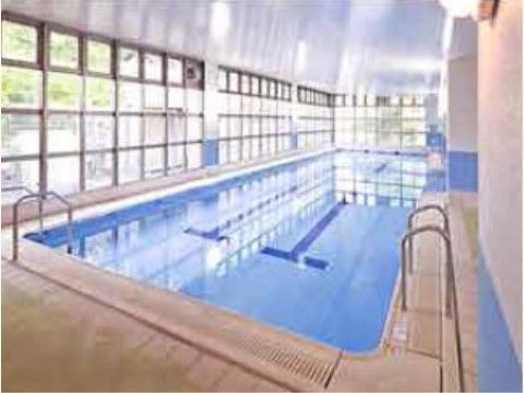 一面ガラス張りの、とても明るい温水プールである。床と壁は白く、プールの入口には手すりが設置されている。