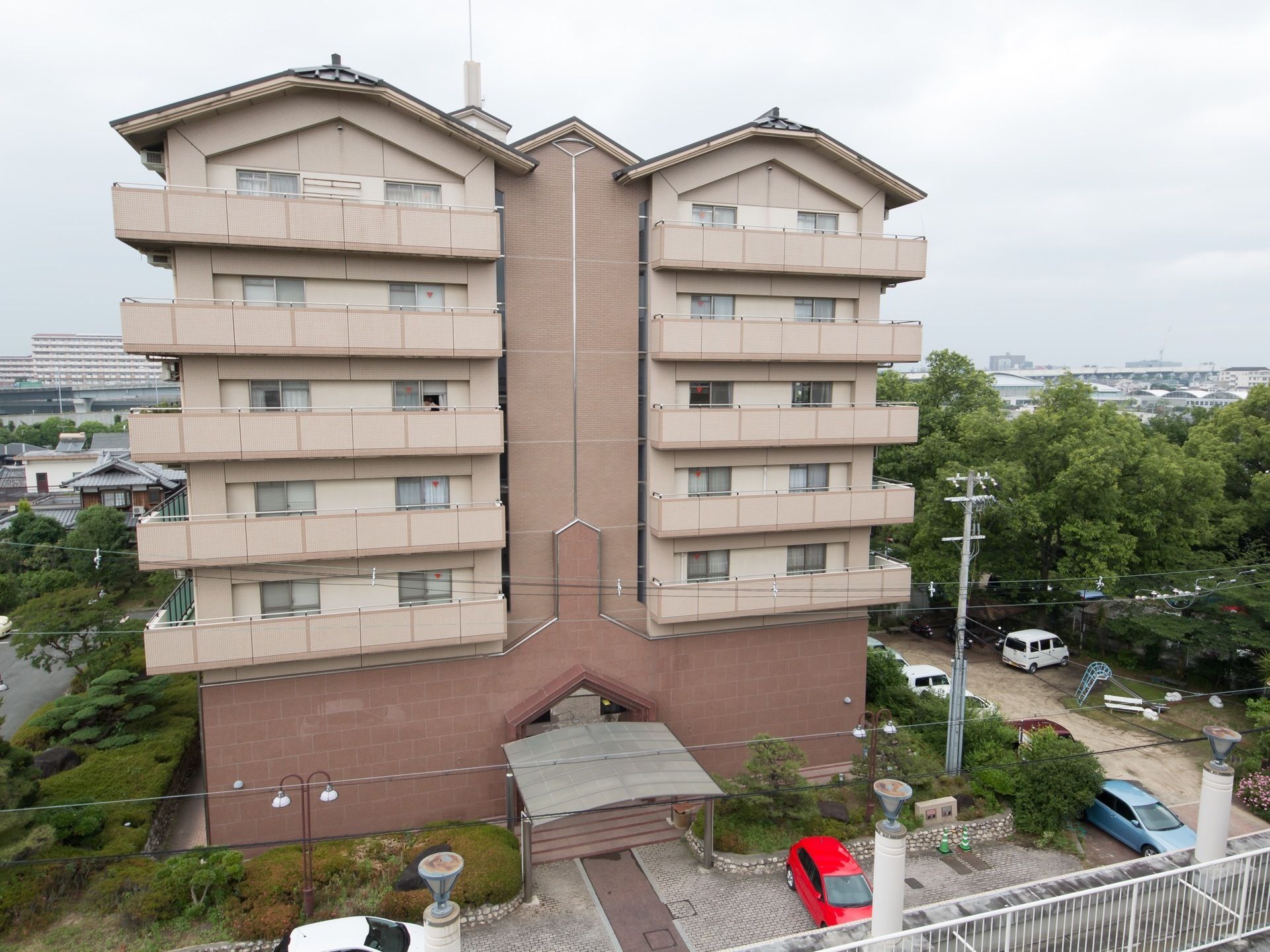木々に囲まれた自然豊かなところに位置しており、存在感を示している。薄いピンクでレンガ調の外観は柔らかな印象を与えてくれる。
