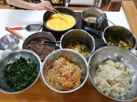 ボウルや鍋に料理が並び、入居者の食事を作っている風景