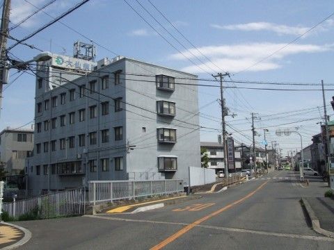 近くに立地する総合病院。周囲は住宅が多く落ち着いた環境の中にある。病院のすぐ近くには広い道路が走っている。