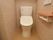コンパクトな空間に洋式トイレが設置されている。トイレの操作パネルの他に、呼び出しベルが取り付けられている。
