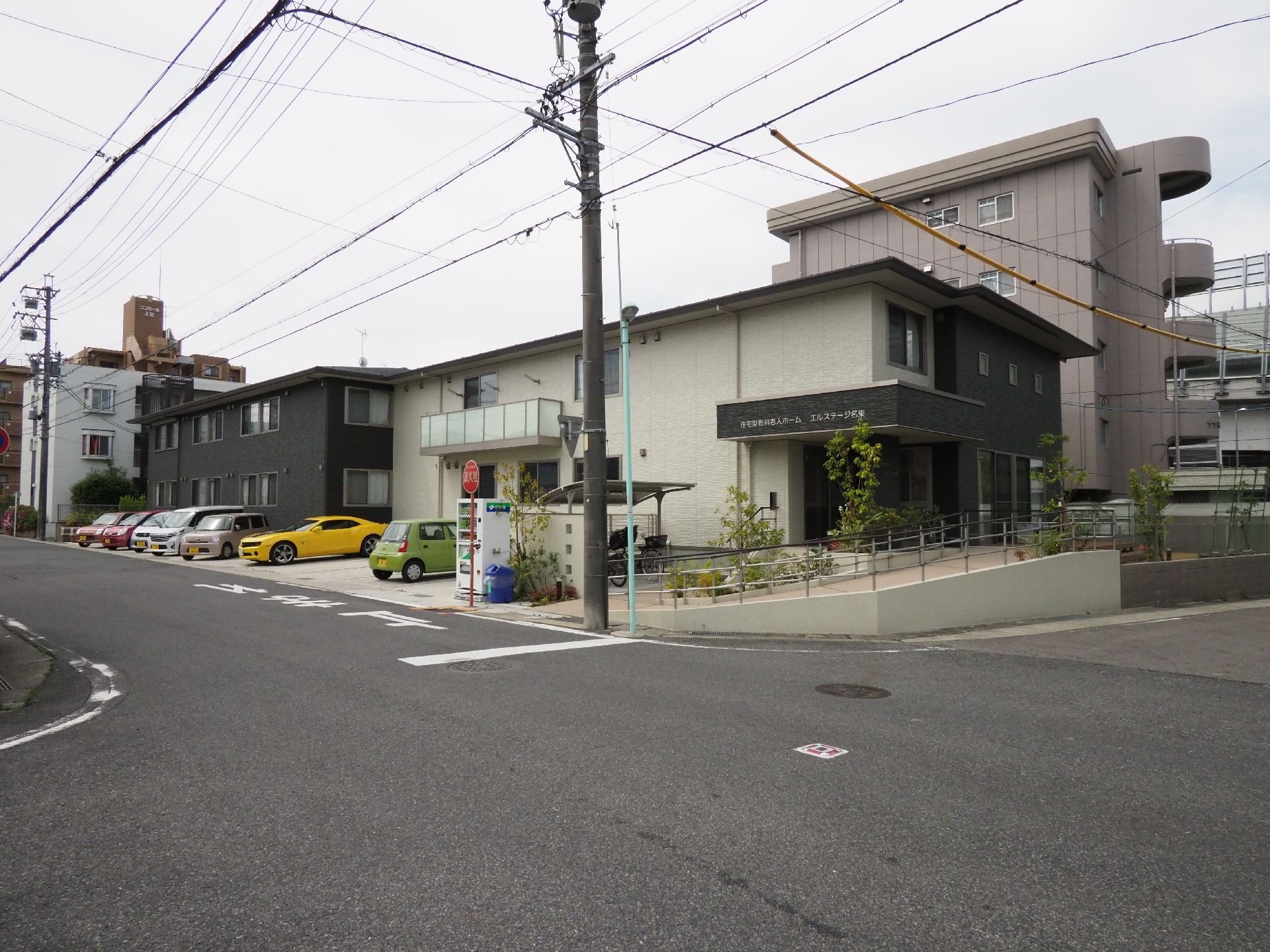 施設は2階建てで、白と暗めのブラウンの外壁に塗り分けられている。周囲には緑が配置されていて、施設をやわらかい印象にしている。