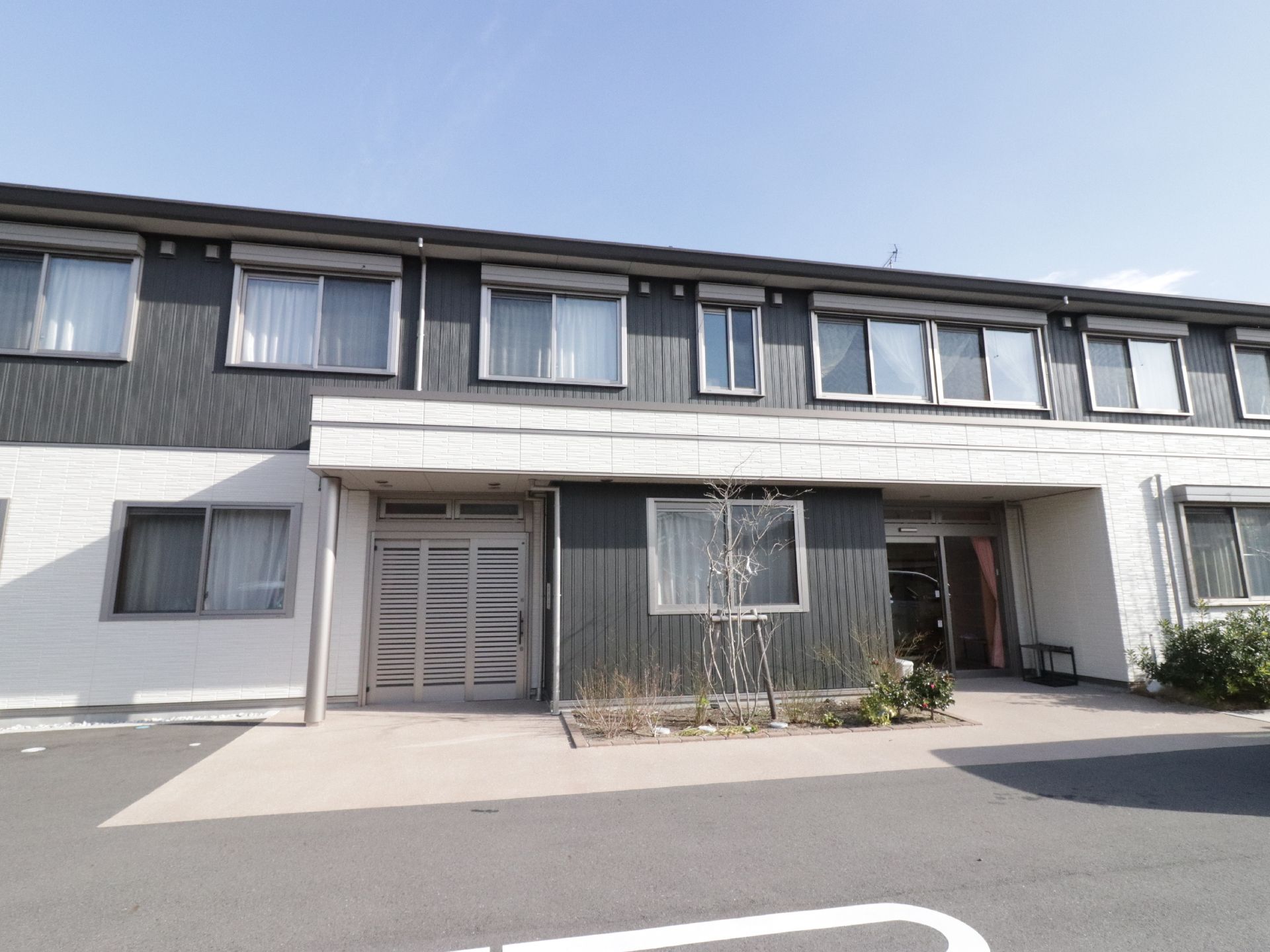 二階建ての施設で前面が駐車場になっている。舗装されてフラットになっているので車椅子での移動も楽にできる。玄関は自動ドアである。