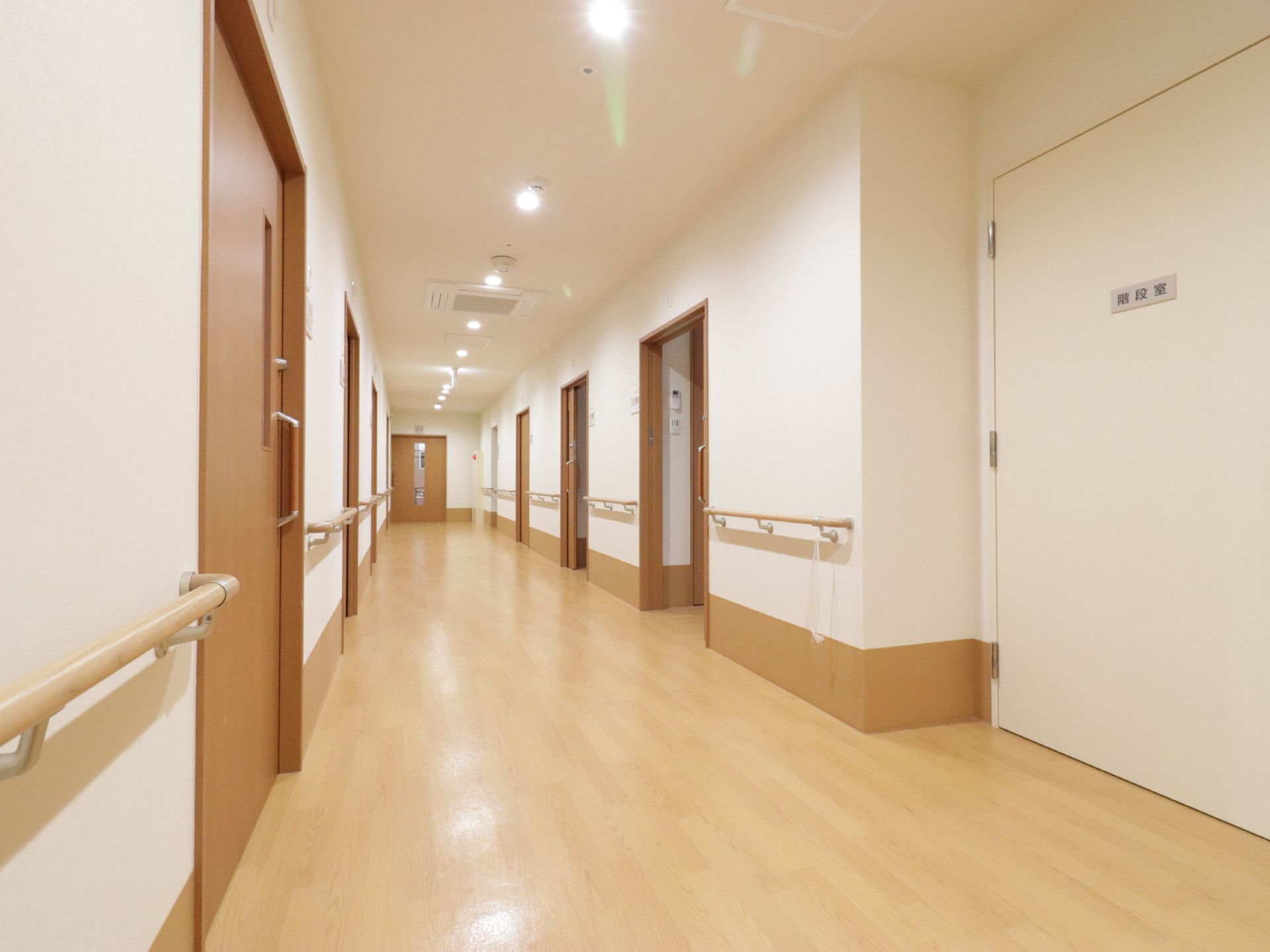 天井には埋め込み式のライトが付いているため明るい廊下になっている。左右に部屋がある。手すりが設置してあるので、掴まりながら歩くことができる。