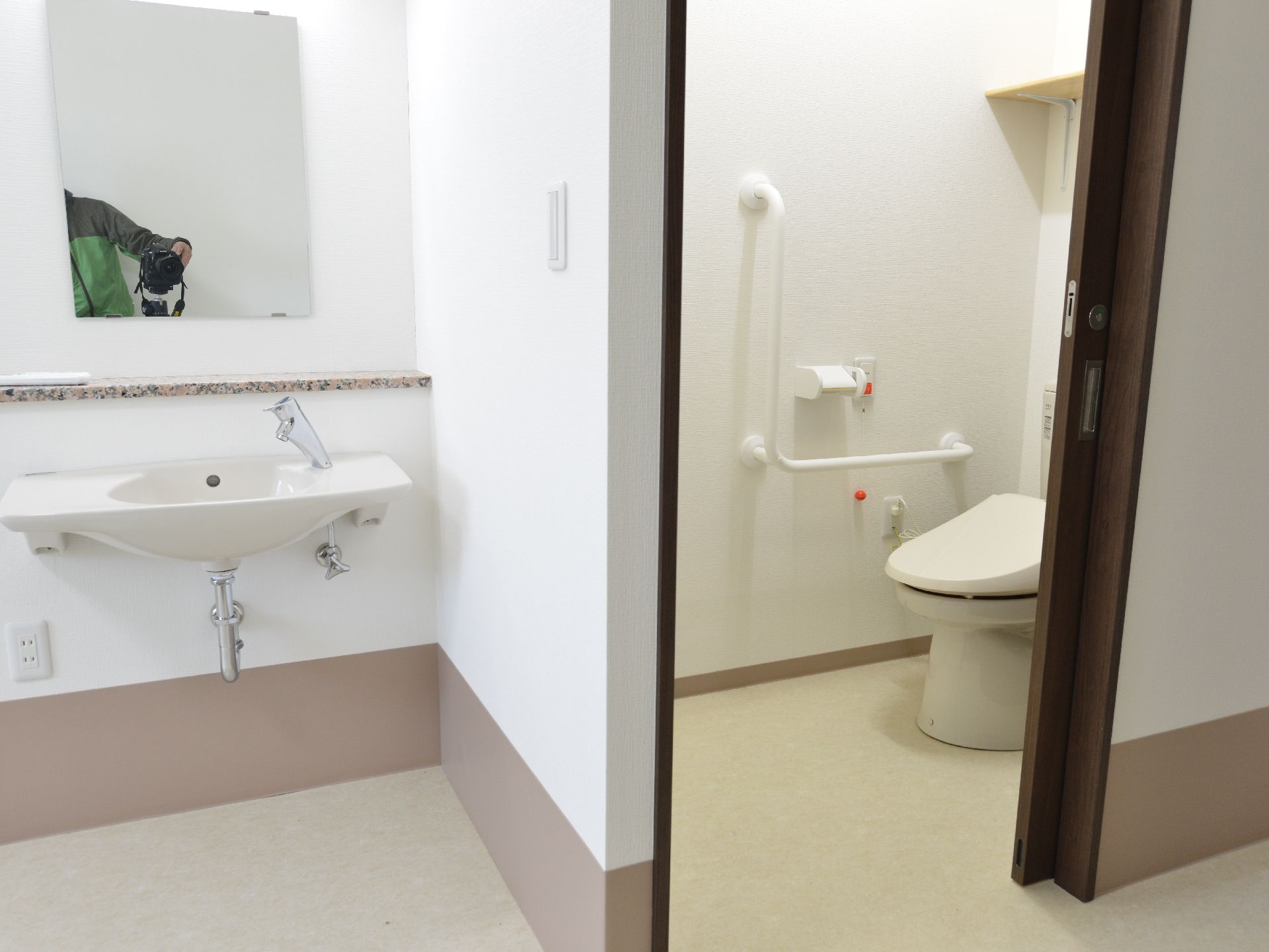 居室にはトイレと洗面台が完備されている。トイレにはL字型の手すりが設置されており、洗面台の上には鏡が取り付けられている。