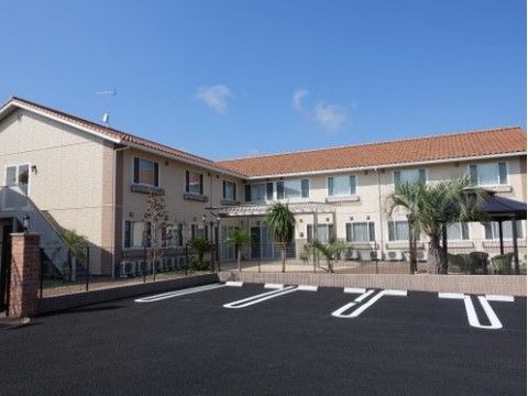 オレンジの屋根が温かみのある外観。２階が該当施設で、１階はグループホームがある。広い庭があり、散策を楽しむことができる。
