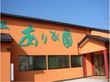 鮮やかなオレンジ色の壁に、褐色の屋根瓦と赤い柱が印象的。上にひさしがある玄関前は、緩やかなスロープなっている。