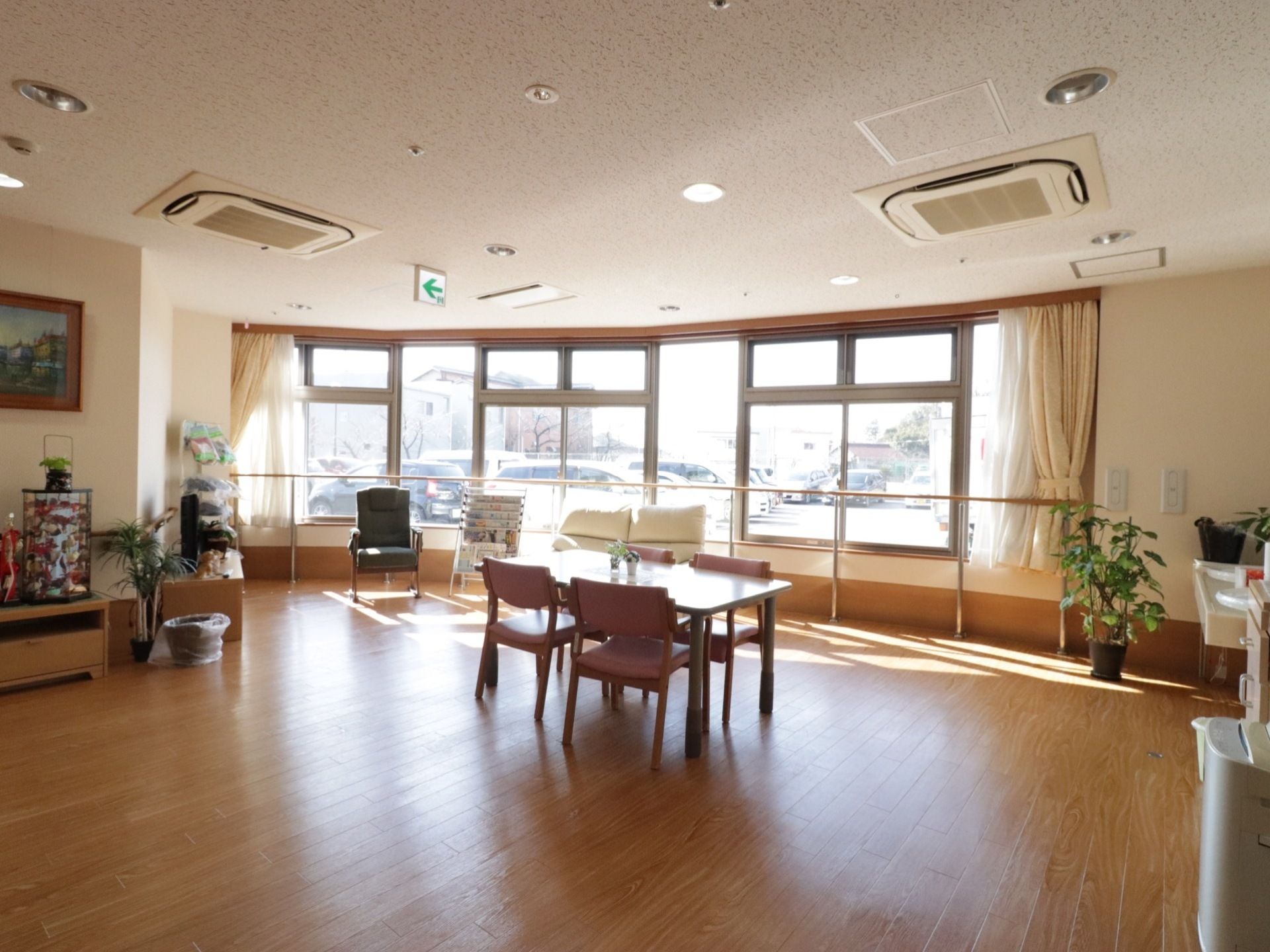 玄関から入ってすぐ左側にある談話室。エントランスのロビーも兼ねており、曲面デザインの窓の外には駐車場が見える。