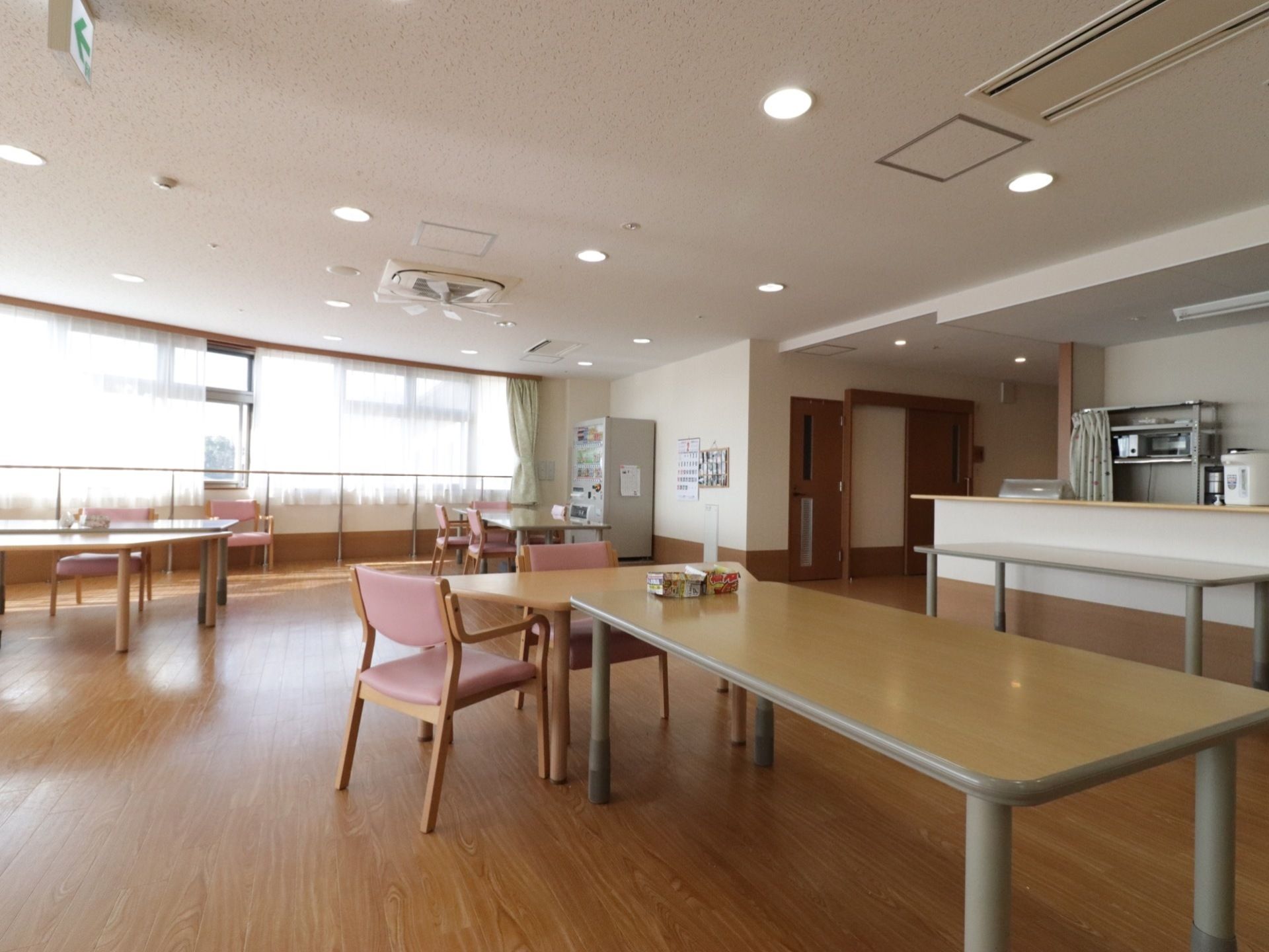 丸い構造で建物の外からも場所が分かる食堂兼リビング。キッチンは、部屋の隅にカウンター式の物が設置されている。