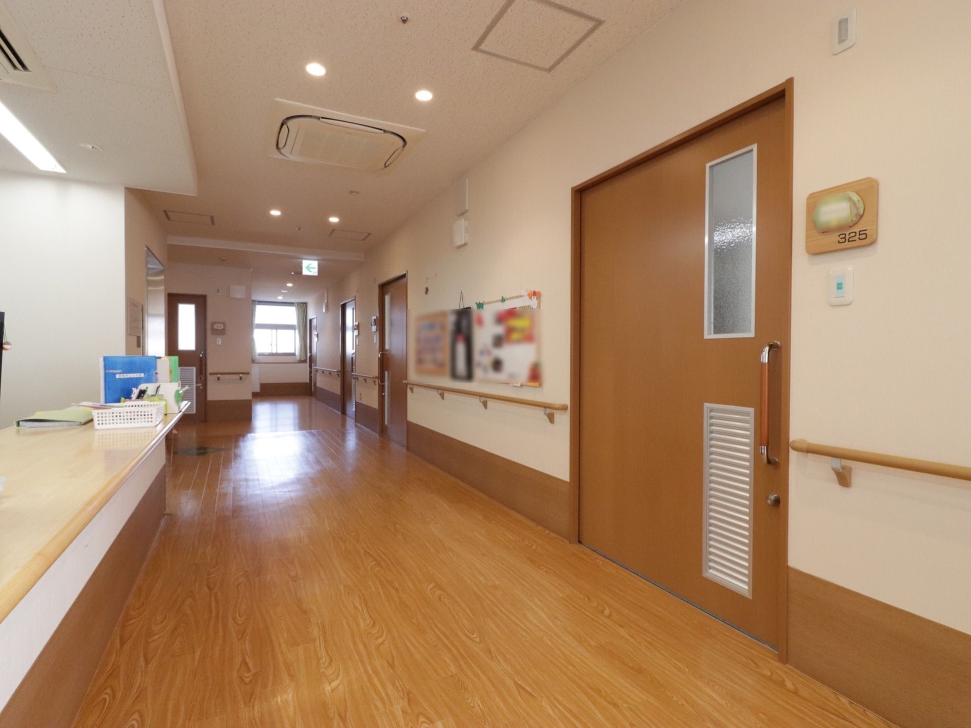 それぞれの居室のドアは幅広のスライドドアを採用しており、脇には部屋番号と表札を兼ねたプレートが取り付けられている。