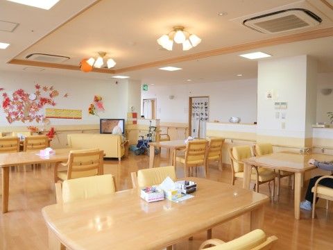 「そんぽの家 高蔵寺」食堂。無垢材で角の丸いダイニングテーブルを置いています。