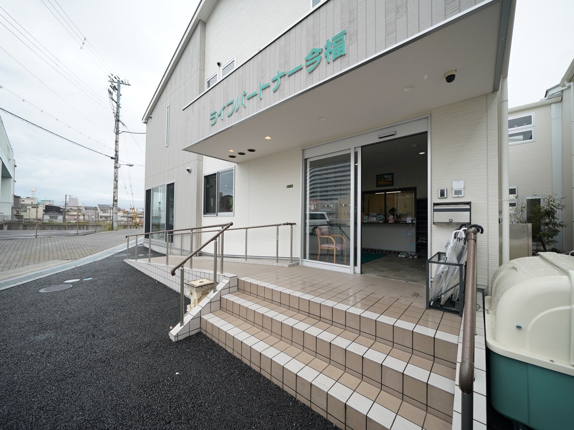 入口付近に傘立てが置いてある、スロープと階段の両方を設けた玄関