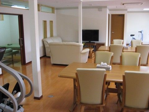 部屋の奥にテレビとソファが置いてあり、ダイニングテーブルセットがある部屋