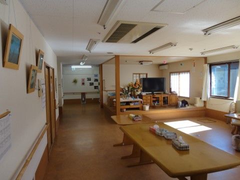 落ち着いた色合いのウッディなテーブルが置かれている。大型テレビの下はテレビラックがあり、アットホームな雰囲気がある。