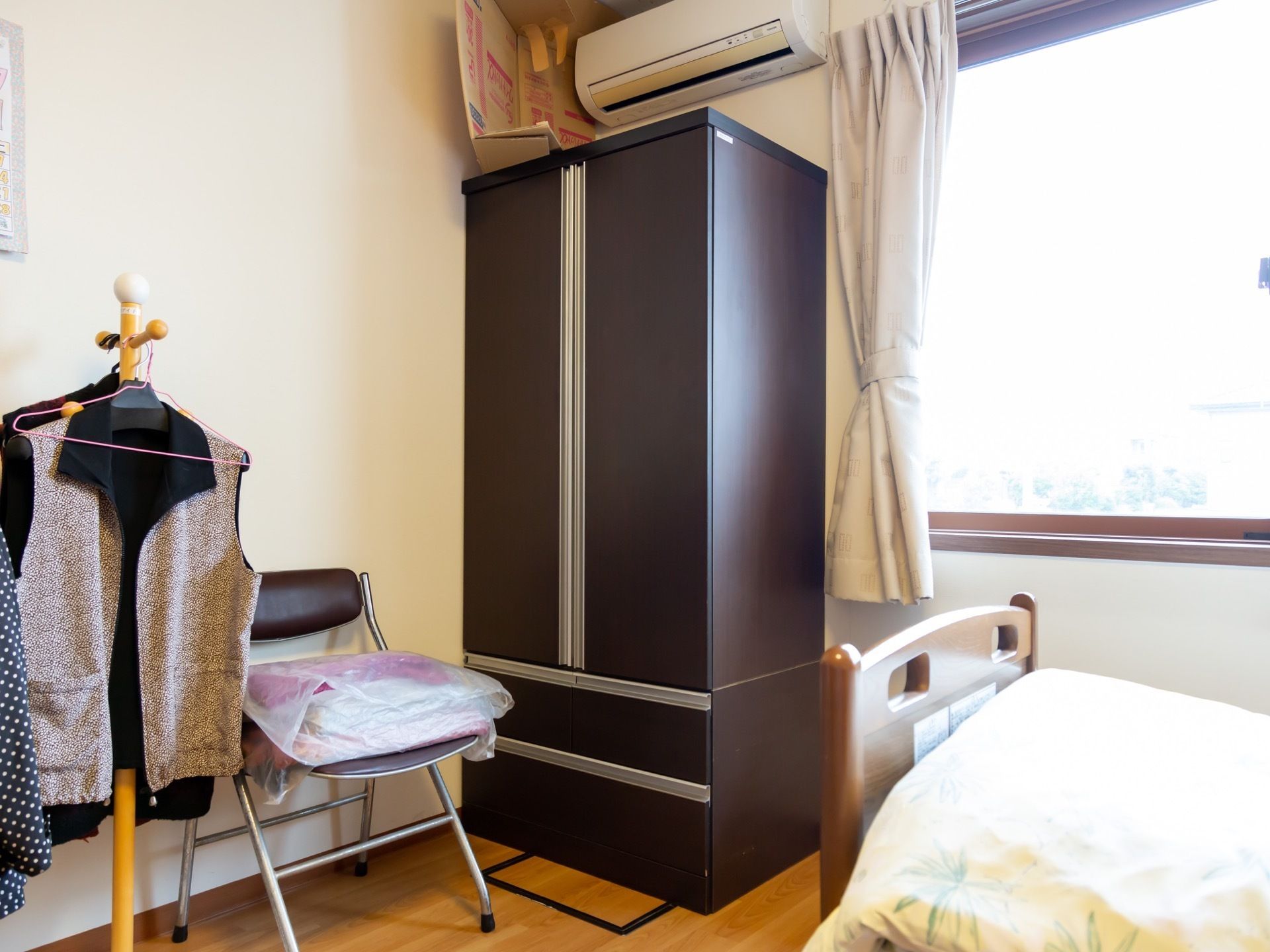 黒い大きなクローゼットがある。級長が備え付けられている。窓からは日の光が入ってくるため部屋が明るい。