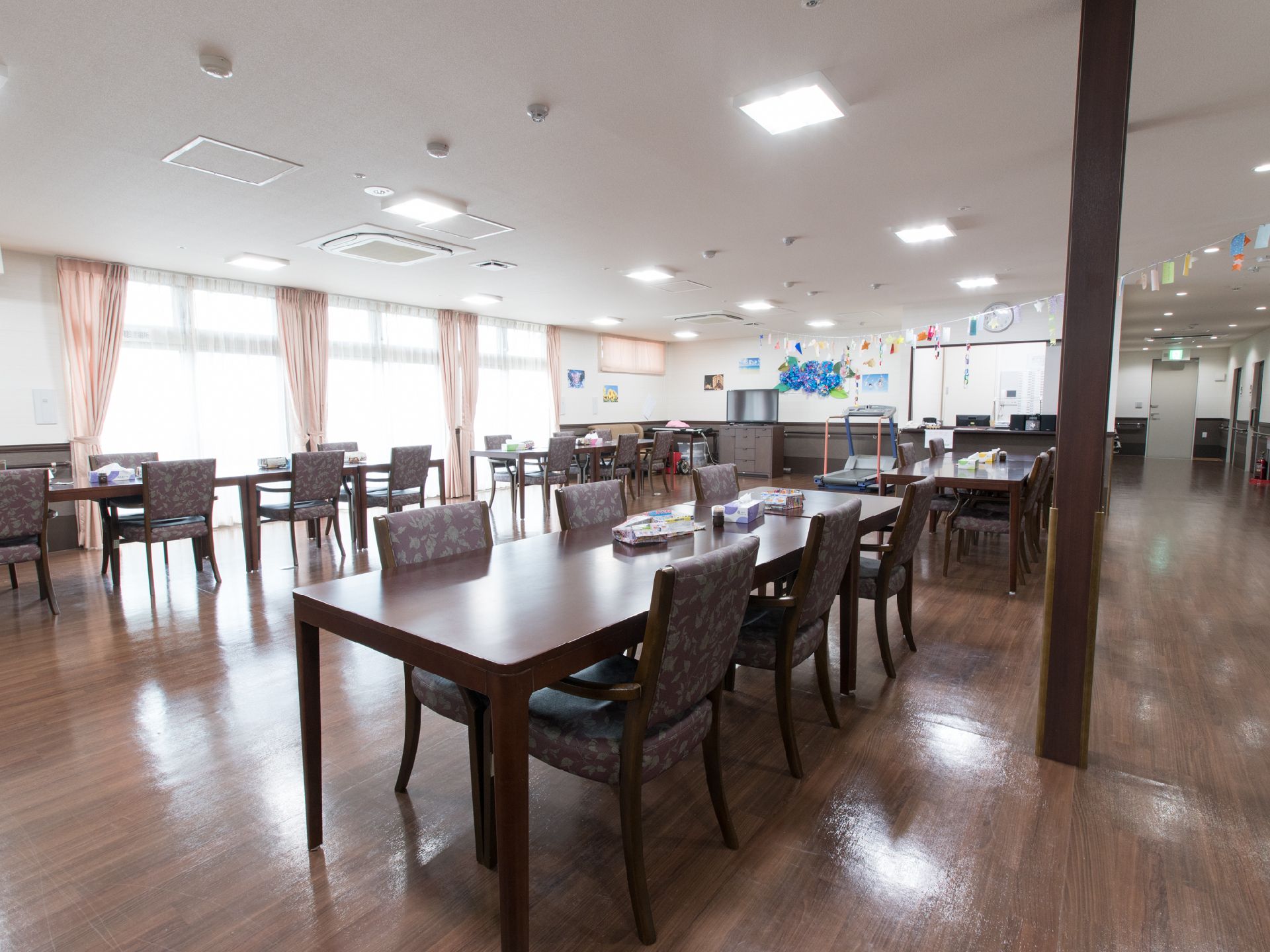 食堂には廊下からそのまま入ることが可能。ひとつのテーブルには、6名ほどが一緒に座ることができる。テーブルなどの色は、床の色に合わせている。
