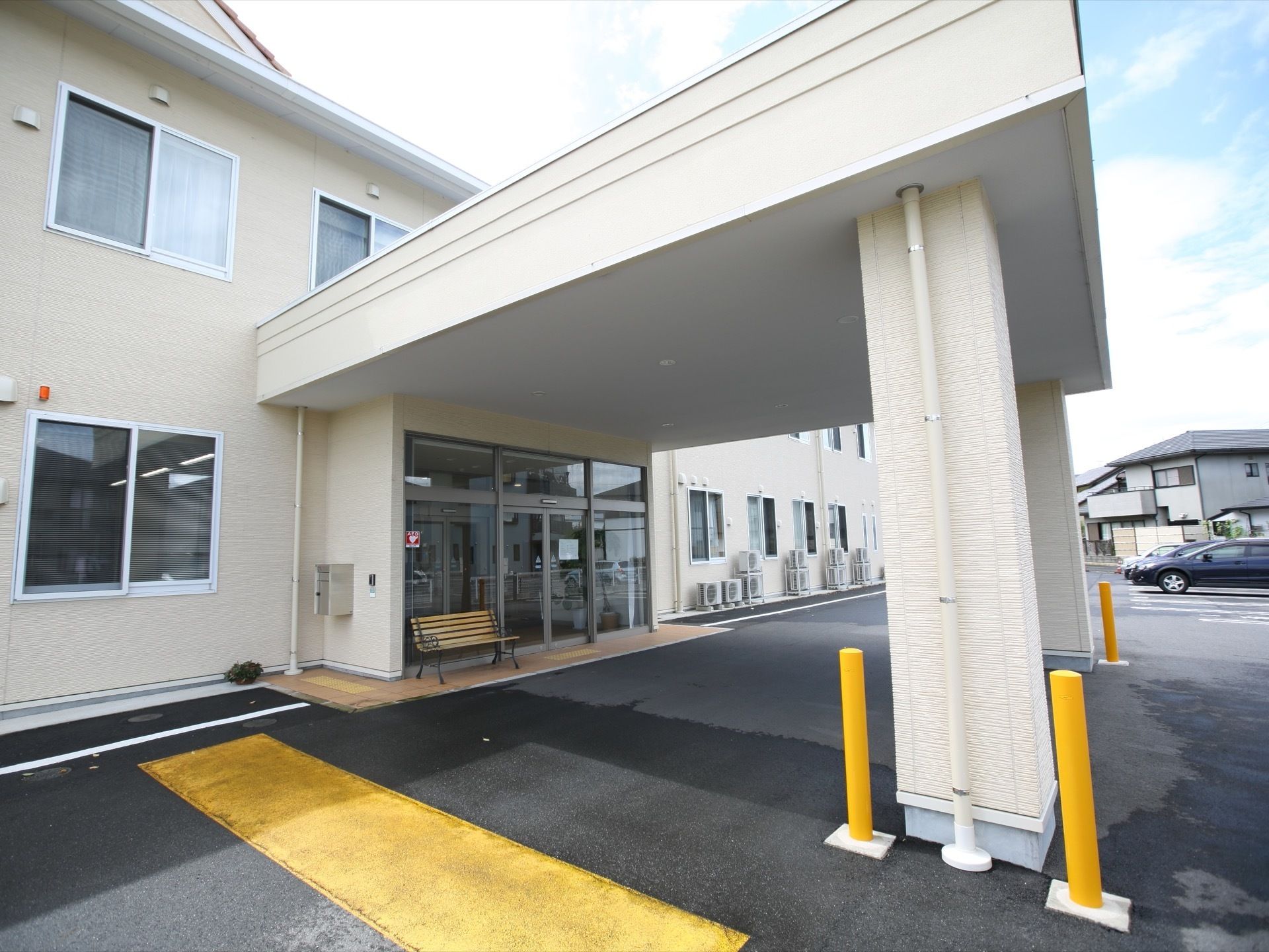 玄関部分には大きな屋根が付いており、車が通り抜けられる広さがある。入り口は自動ドアになっていて、横にはベンチが置かれている。