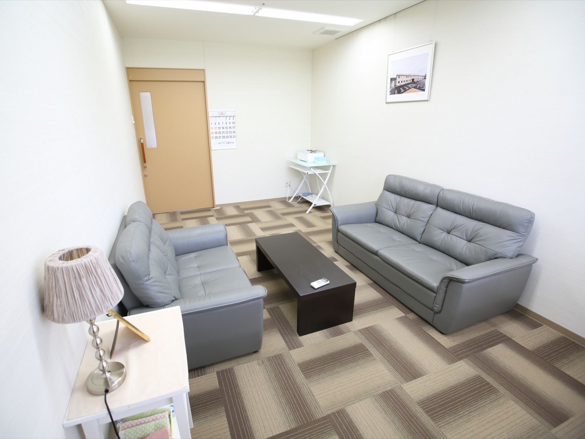 談話室にはソファが向かい合って設置されており、間には細長いテーブルが置かれている。壁にはカレンダーや絵画などが飾られている。