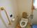 トイレには温水洗浄便座が設置されており、後ろには背もたれが付いている。便器の右側には可動式の手すりが備えられている。