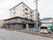 5階建てのマンションのような建物で、玄関のある手前の1、2階は民家のように見える造りである。手前に駐車場がある。