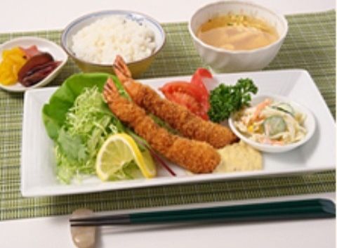 千切りキャベツとトマトが添えられたエビフライがメインの食事