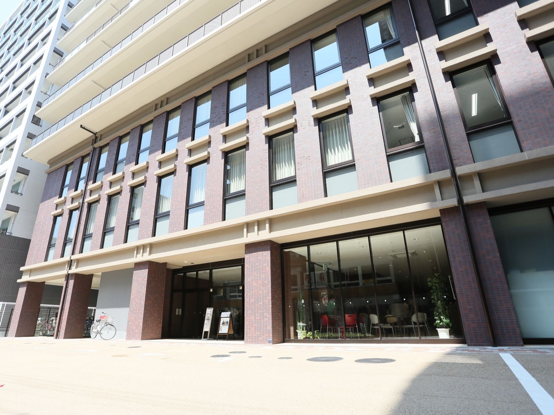 ３階までは茶系のレンガ貼りになっていて、窓がたくさん設置されている。玄関前はとても広いスペースがあり、バリアフリーである。