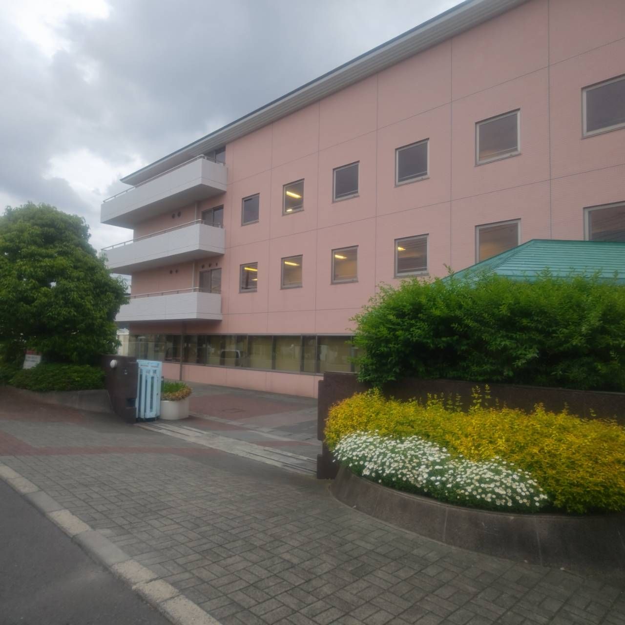 建物の外壁に付いている施設名。玄関右手に控え目に表示されている。落ち着いた雰囲気。カタカナと漢字表記なので年配の人もわかりやすい。