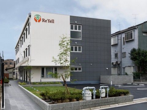 3台分の駐車スペースがある、当施設の3階建ての外観と駐車場