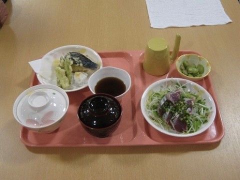 仕切りが設けられたピンクのトレーに、食事がきれいに並べられている。本日はお魚がメインの豪華な食事である。