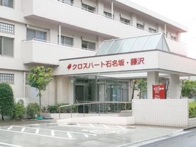 周りに木々が植えられエントランスに手すりが設置された建物