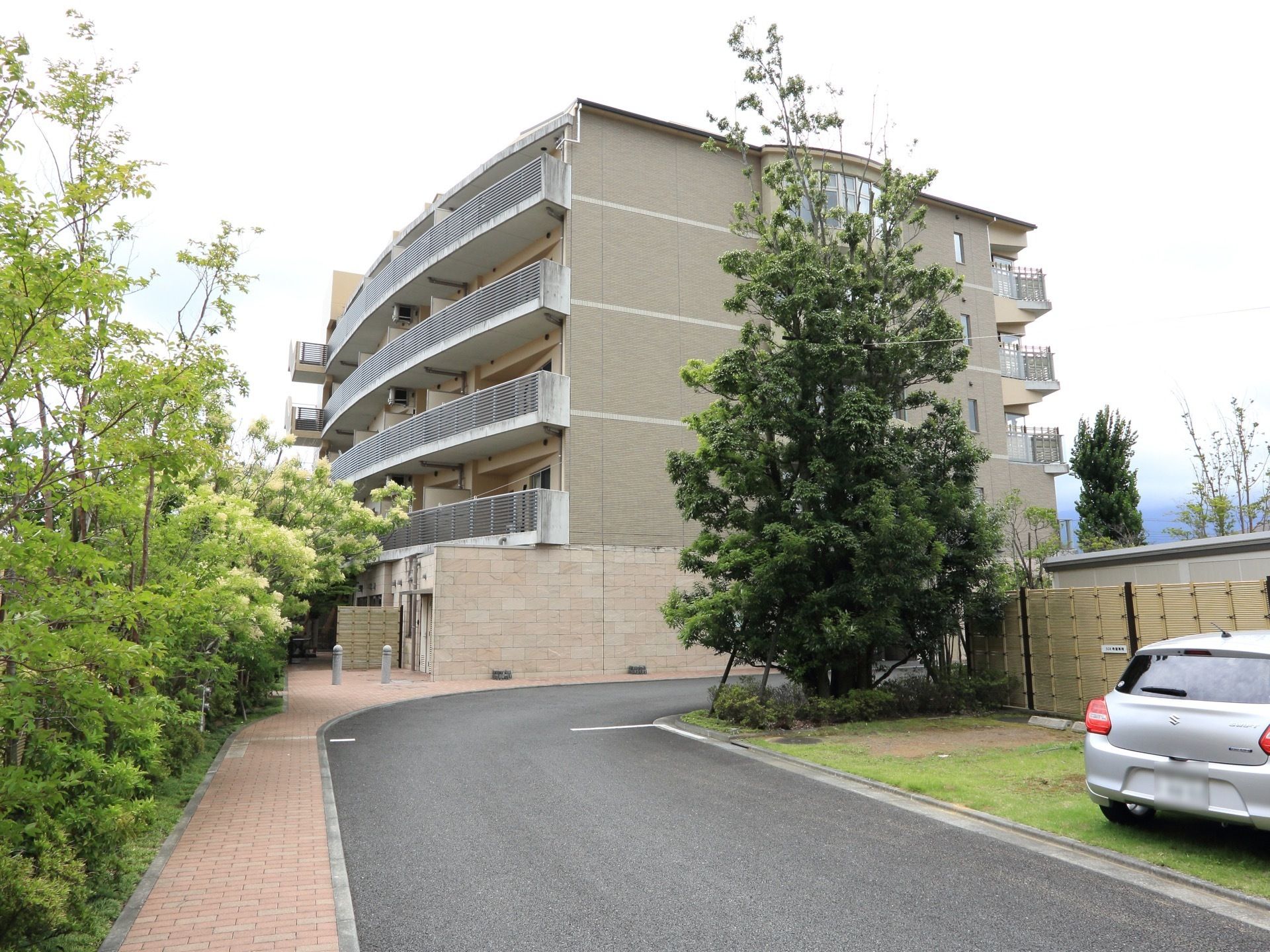 施設はホテルのような高級感のある見た目である。車道の横にはブロックの歩道があり、緑を感じて心地よく散歩ができる。