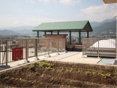 屋上には畑のスペースがあり野菜作りができるようになっている。屋根の付いた足湯の設備からは周囲の山々を眺めることができる。