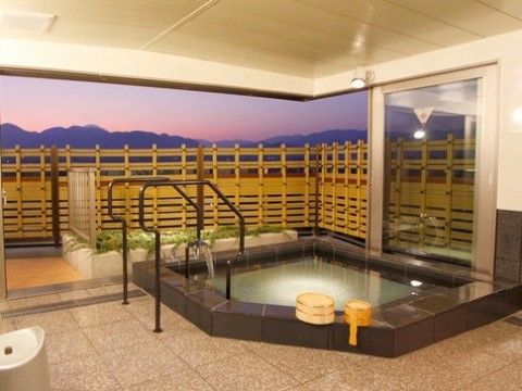 屋根の付いた露天風呂の浴槽には手すりが設置されている。周囲は竹製の柵で囲まれ、遠景の山の景色を眺めることができる。