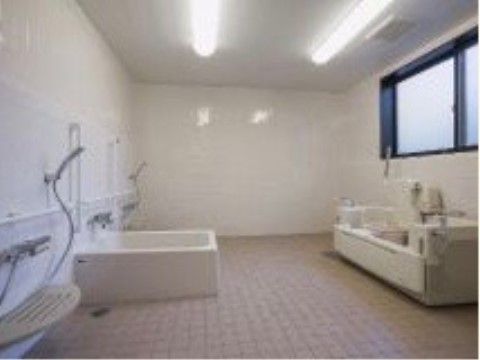 かなり広めの共同浴室。通常の浴槽と介護用の浴槽の２種類が設置されている。シャワーも複数備え付けられている。