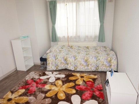 華やかなベッドシーツとカーペットが印象的なご入居者様の個室