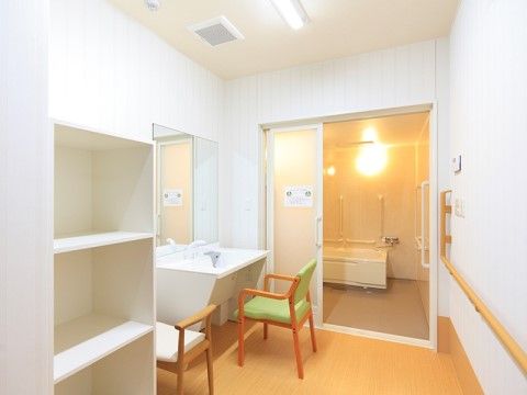浴室は、壁が白く清潔感のある明るい空間となっている。手すりを設置したので、安全に移動していただける。