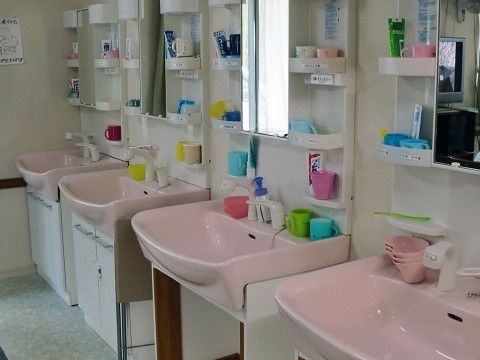 きれいに磨かれた洗面台である。入居者様の洗面具が置いてある棚には入居者様の名前がラベルで貼られており、一目で判別ができるようにしている。