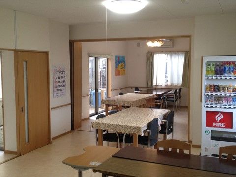 ホールには幅の広いスライド式の扉を通じて出入りすることができる。室内の壁にはカレンダーや絵画が飾られている。
