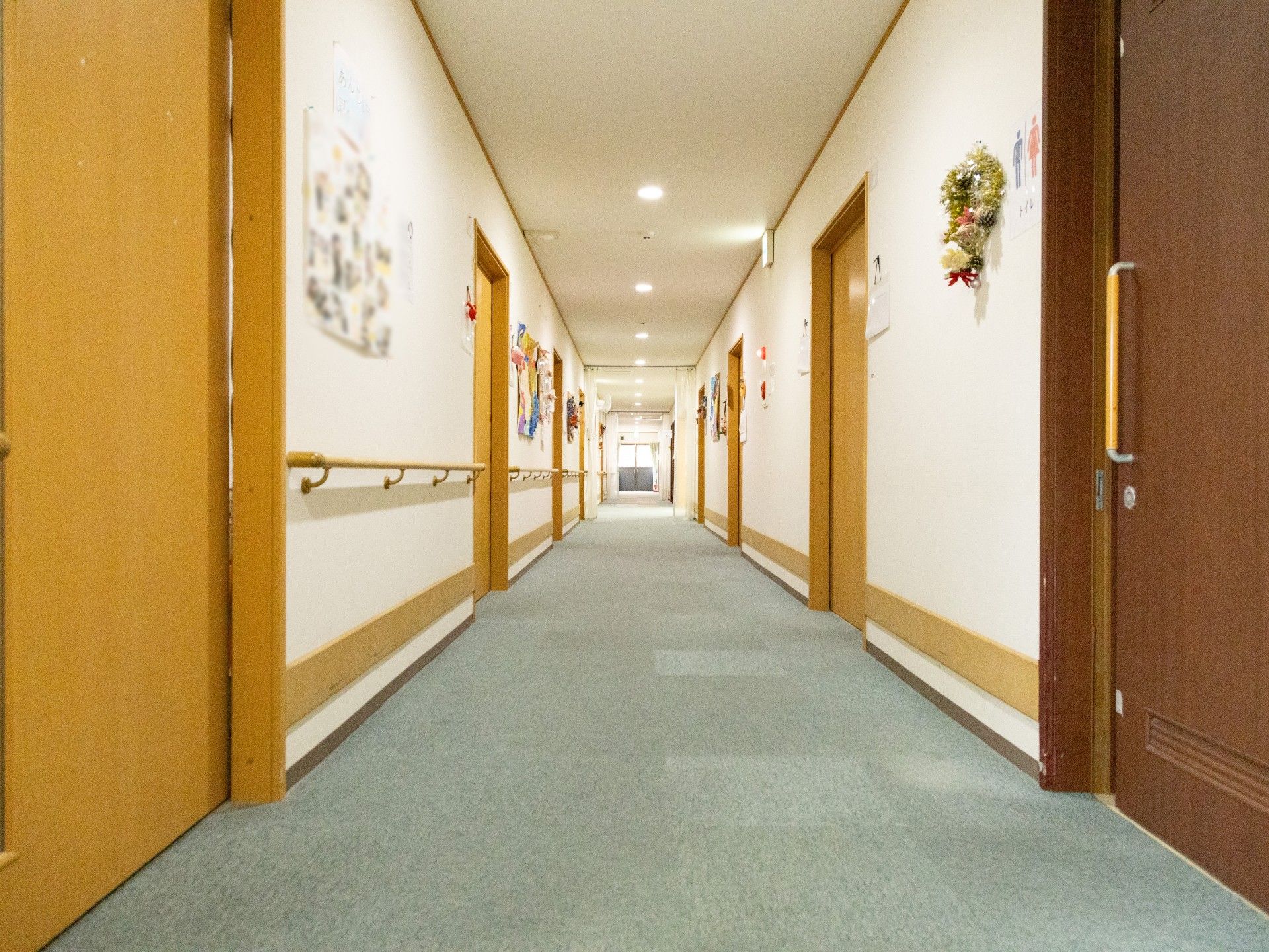 ご入居者様の膝に手を置いて、同じ目線でお話しするスタッフ