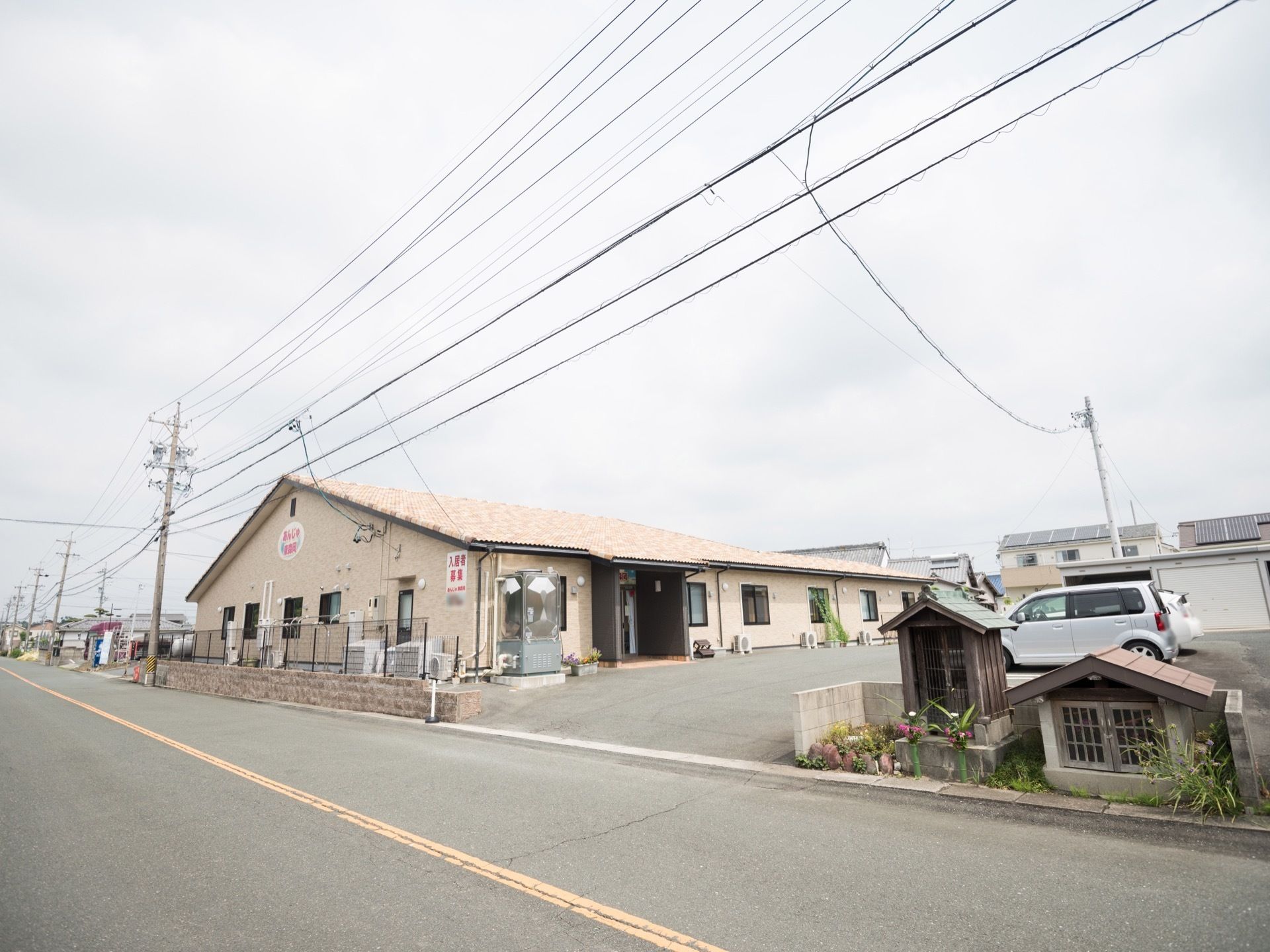 アットホームな雰囲気のある平屋建ての建物である。広々とした敷地内には駐車スペースがゆったりと配置されている。